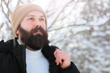Palto ve İskoç kumaşlı yakışıklı bir adamın açık hava portresi. Sıradan kış modası.