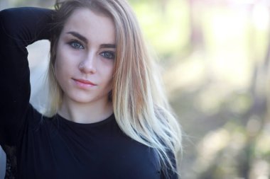 Yaz parkında yürüyüşe çıkan güzel bir kız. Şehir parkında yapraklar dökülüyor. Sonbaharın başlangıcı. Eylül.