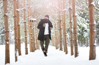 Palto ve İskoç kumaşlı yakışıklı bir adamın açık hava portresi. Sıradan kış modası.