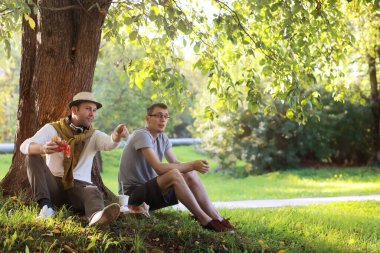 Bir adam sıcak bir günde ağaçların gölgesinde saklanır. Yemek molası. Günün ortasında dinlenin..
