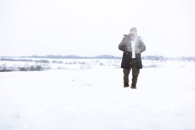 Palto ve İskoç kumaşlı yakışıklı bir adamın açık hava portresi. Sıradan kış modası.