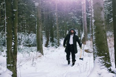 Kış ormanlarında sakallı adam. Çekici, mutlu, sakallı genç bir adam parkta yürüyor..