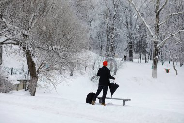 Şemsiyeli bir kış yürüyüşü. Şemsiyeli bir adam, kış manzarasının arka planında yürür, kış manzarası