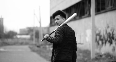 Kameraya poz veren Asyalı bir gencin siyah beyaz fotoğrafı.