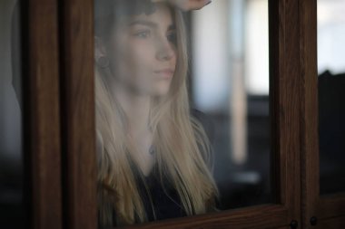 Genç bir kız büyük bir dairede dinleniyor.