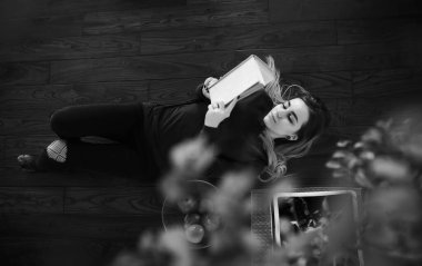 Genç bir kız büyük bir dairede dinleniyor.