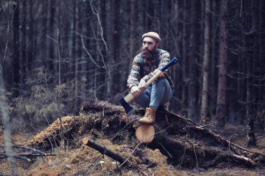 Yağmurlu havada sonbahar parkı ve şemsiyeli genç bir adam.