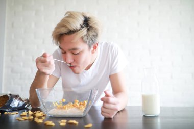 Kahvaltıda genç bir Asyalı çocuk için sütlü mısır gevreği.