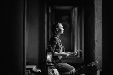 Eski evdeki eski kız kitap okuyor ve bir rüya yazıyor.