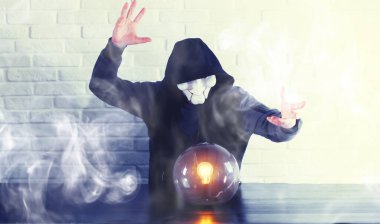 Masasında falcı topu olan bir adam.