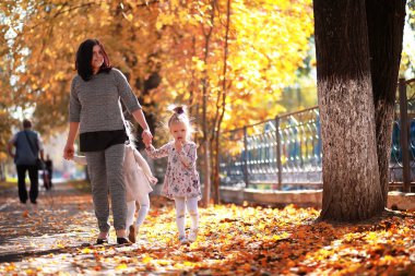 Yaprak parkta düşer. Sonbahar parkında yürüyüşe çıkmış çocuklar. - Aile. Düş! Mutluluk.