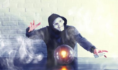 Masasında falcı topu olan bir adam.