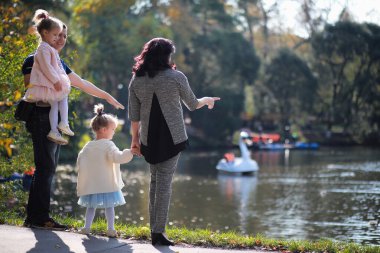 Yaprak parkta düşer. Sonbahar parkında yürüyüşe çıkmış çocuklar. - Aile. Düş! Mutluluk.