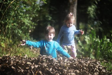 Yaprak parkta düşer. Sonbahar parkında yürüyüşe çıkmış çocuklar. - Aile. Düş! Mutluluk.