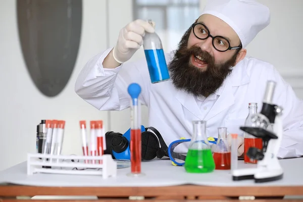 Chemist crazy. A mad scientist conducts experiments in scientific laboratory. Performs research using a microscope.