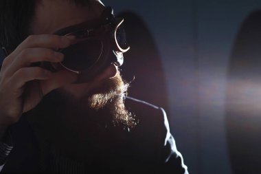 Takım elbiseli sakallı bir adam elinde bir nesne tutuyor. Zaman ve fikir kavramı. Özlem geliştirme.