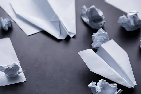 テーブルの上の紙飛行機 暗い背景の折り紙モデル コンセプト 創造的な廃棄物時間 — ストック写真