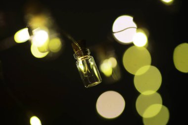 Cam şişelerden oluşan Noel çelengi, içinde bitki olan kavanozlar. Yeni yıl ve Noel konsepti. Ampullerden bir çelenk Güzel bir ışık ve boke