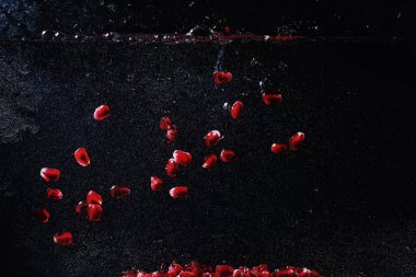 Olgun tatlı nar tohumlarına su damlaları düşer. Metnin için kopyalama alanı olan taze nar arkaplanı. Vejetaryen ve vejetaryen kavramı.