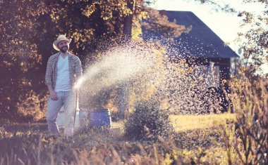 Sunse akşam bir sebze bahçesi sulama Adam çiftçi