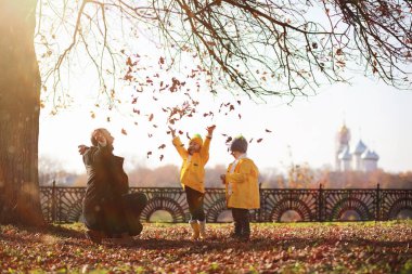 Çocuklar sonbahar parkında sonbaharda yürürler