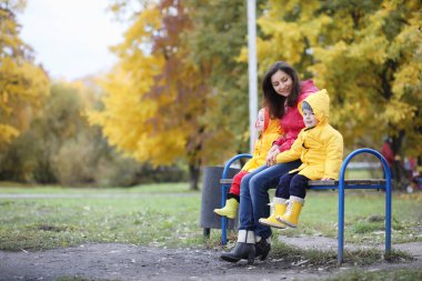 Sonbaharda dışarıda yürüyüş yapmak için yağmurluk giymiş bir çocuk.