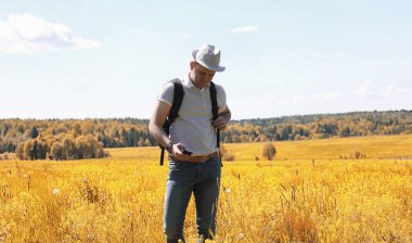 Genç adam bir yaz gününde sırt çantasıyla gezer.