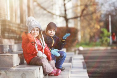 Çocuklar sonbahar parkında sonbaharda yürürler