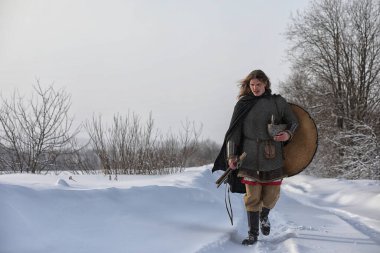 Defender'ı posta zırh genç savaşçı bir kılıç ve balta ile silahlı