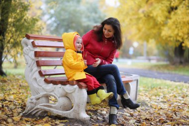 Sonbaharda dışarıda yürüyüş yapmak için yağmurluk giymiş bir çocuk.