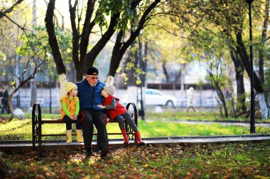 Çocuklar sonbahar parkında sonbaharda yürürler