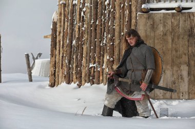 Defender'ı posta zırh genç savaşçı bir kılıç ve balta ile silahlı