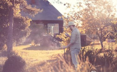 Sunse akşam bir sebze bahçesi sulama Adam çiftçi