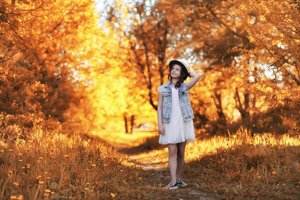 Girl walking in the autumn park. Autumn in the city, girl with dad for a walk. Parents are walking with little children. Autumn par