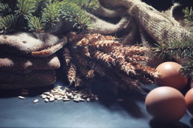 Siyah bir masada buğday ve glüten ile taze somun ekmek. Fırın ve market konsepti. Taze, sağlıklı çavdar ve beyaz somun ekmeği, çuval bezi üzerine serpiştirilmiş un. Tahıllı taze ev yapımı ekmek..