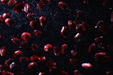 Olgun tatlı nar tohumlarına su damlaları düşer. Metnin için kopyalama alanı olan taze nar arkaplanı. Vejetaryen ve vejetaryen kavramı.