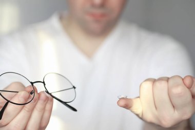 Kötü görüş kavramı. Kontak lens ve gözlüğü elinizde tutun. Reklam gözlükleri ve lensler için poster.