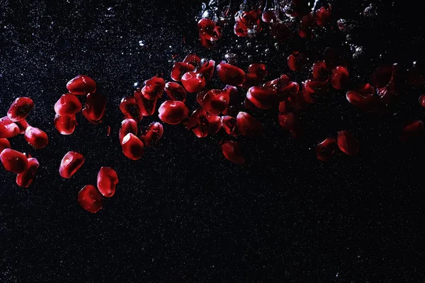 Olgun tatlı nar tohumlarına su damlaları düşer. Metnin için kopyalama alanı olan taze nar arkaplanı. Vejetaryen ve vejetaryen kavramı.