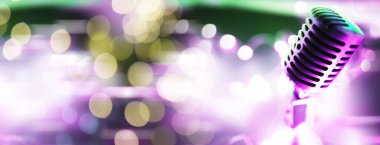 Arka planda arka ışıklandırmalı Retro tarzı mikrofon. Ses, müzik ve karaoke için klasik gümüş mikrofon. Konuşma yayın ekipmanı. Canlı pop, rock müzik performansı. Seçici odak