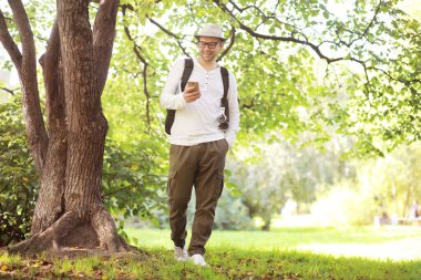 Bir adam sıcak bir günde ağaçların gölgesinde saklanır. Yemek molası. Günün ortasında dinlenin..