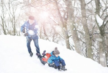 Kışın parktaki çocuklar. Çocuklar parkta karla oynarlar. Kardan adam heykeli yapıp tepelerden aşağı kayıyorlar..