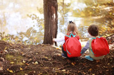 Parkta yürüyüş yapmak için çantalı çocuklar. Okul tatili. Çocuk eğitiminin başlangıcı..