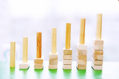 Dağıtılmış tahta blokların üzerinde duran tahta bloklar, kazanma, başarı, meydan okuma, üst konuma adım soyut arka plan konsepti.