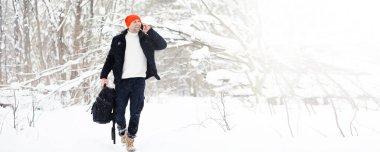 Kışın ormanda bir adam. Sırt çantalı bir turist kışın ormana gider..