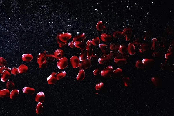 Olgun tatlı nar tohumlarına su damlaları düşer. Metnin için kopyalama alanı olan taze nar arkaplanı. Vejetaryen ve vejetaryen kavramı.