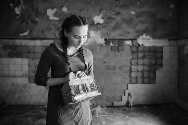 Eski evdeki eski kız kitap okuyor ve bir rüya yazıyor.