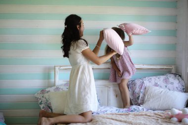 Sabah tembelliği. Anne ve kızı yatak odasında iyi eğlenceler.