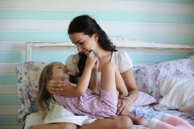 Sabah tembelliği. Anne ve kızı yatak odasında iyi eğlenceler.