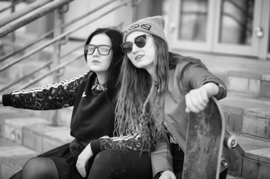 Genç hippi kız bir kaykay sürme. Kızlar kız şehirde bir kaykay ile yürüyüşe. Bahar spor bir kaykay ile sokakta