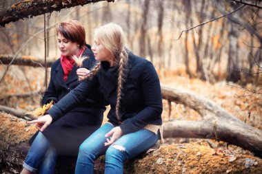 Genç bir kız sonbahar bahçesinde yürüyüşe çıkmış.